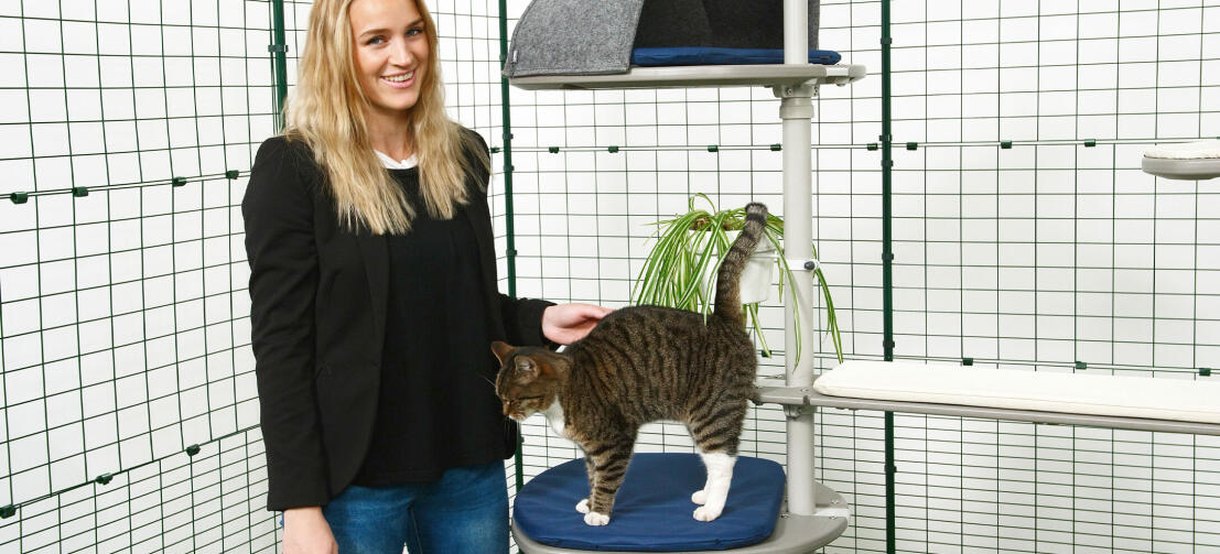 Girl petting her cat which is playing on the Freestyle outdoor cat tree