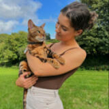 Woman holding her cat in the garden