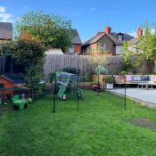 A chicken fencing installed in a garden besides a patio