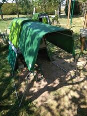 A Go up chicken coop with a run attached and a cover over the top