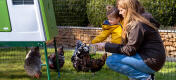 Mother and daugter tending to chickens