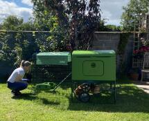 Lady with green Omlet Eglu Cube large chicken coop and run