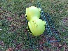 A green grub feeder attached to a stand