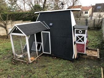 Omlet grey automatic chicken coop door attached to wooden chicken coop