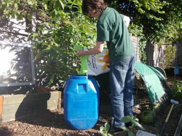 Tam loading the bin with yummy organic feed 