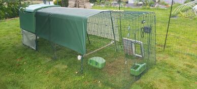 A coop and several accessories including covers, a perch, feeder, drinker and an automatic door attached to its run