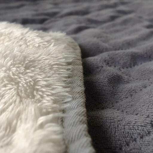 The blanket is dual-sided with a stylish quilted grey on one side and a luxury, cream sherpa on the reverse.