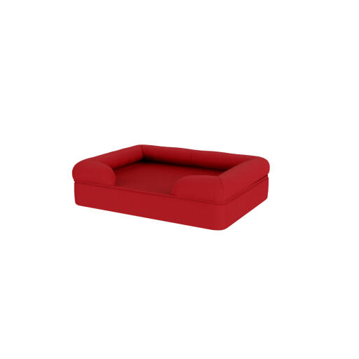 A red bolster dog bed on a white background.