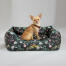 Chihuahua sitting in an Omlet nest bed in the midnight meadow pattern