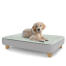 A puppy resting on the large Topology puppy bed with square wooden feet