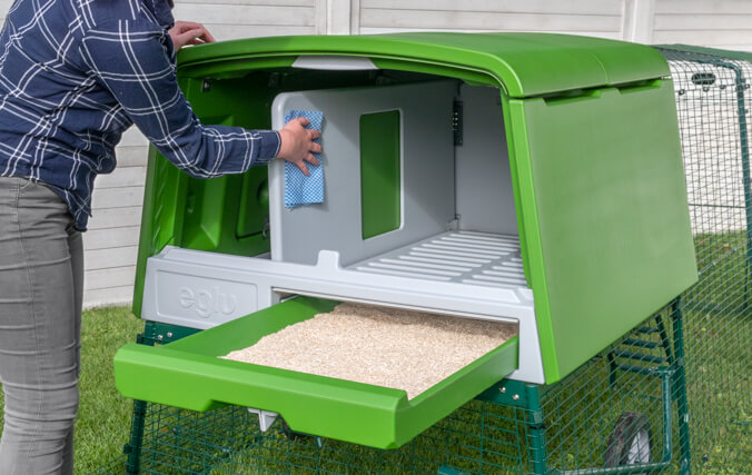 Girl cleaning the Eglu Cube Chicken Coop