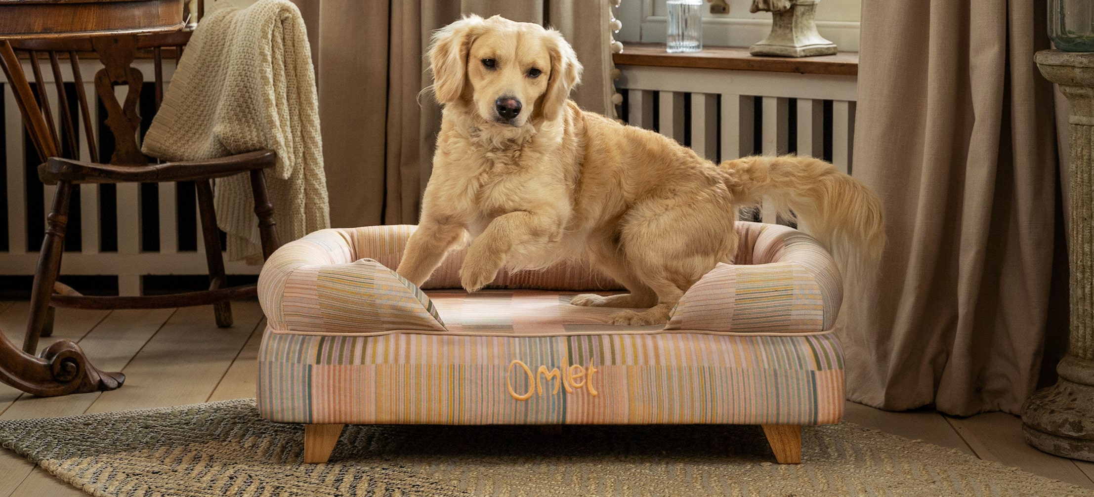 A Golden Retriever using their Omlet Bolster dog bed in Pawsteps Natural