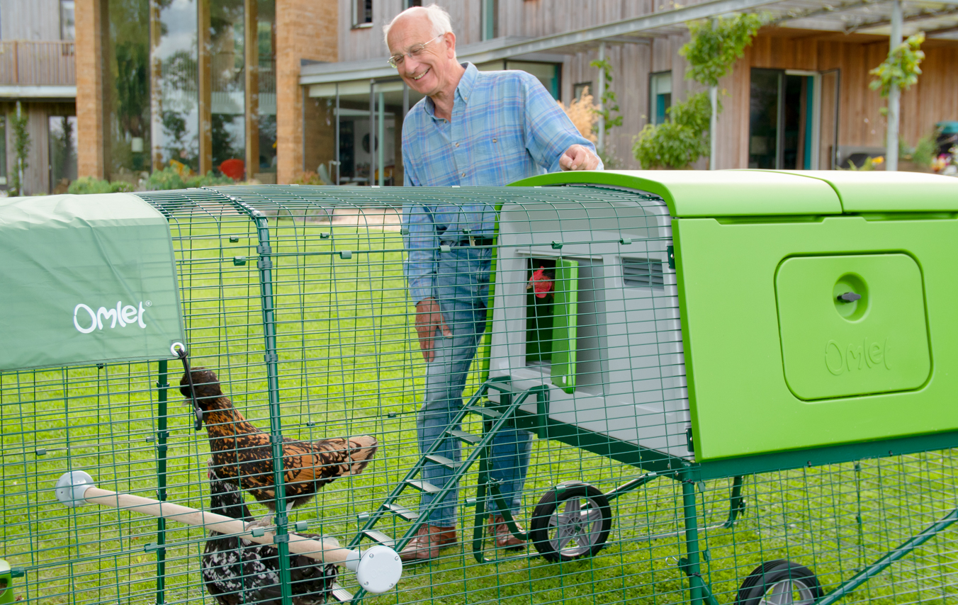 man in a garden with his easy to move large chicken coop