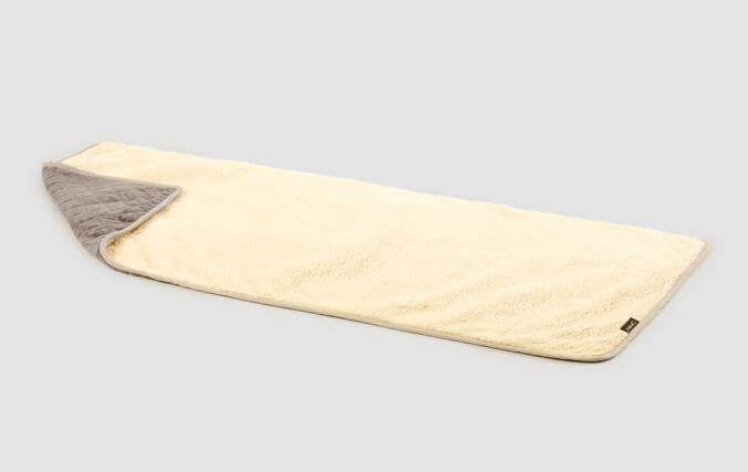 On one side of the cat blanket is a quilted grey plush, and on the reverse is a luxury cream sherpa.