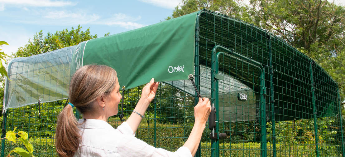 Woman attaching the catio cover for the outdoor walk in run